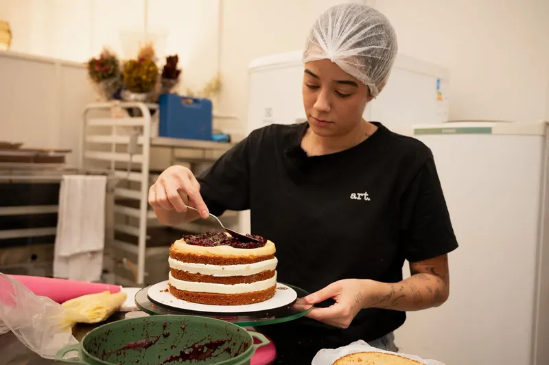 Luiza finalizando bolo com geleia