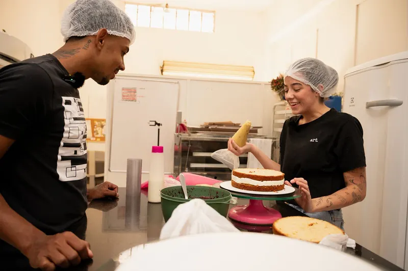 Luiza decorando bolo com confeitaria artesanal